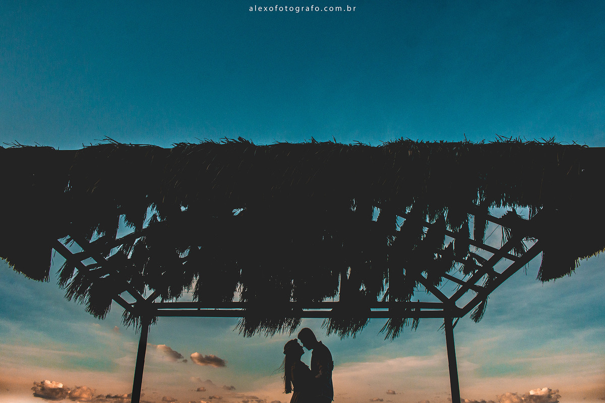 silhueta de casal debaixo de tenda e céu azulado