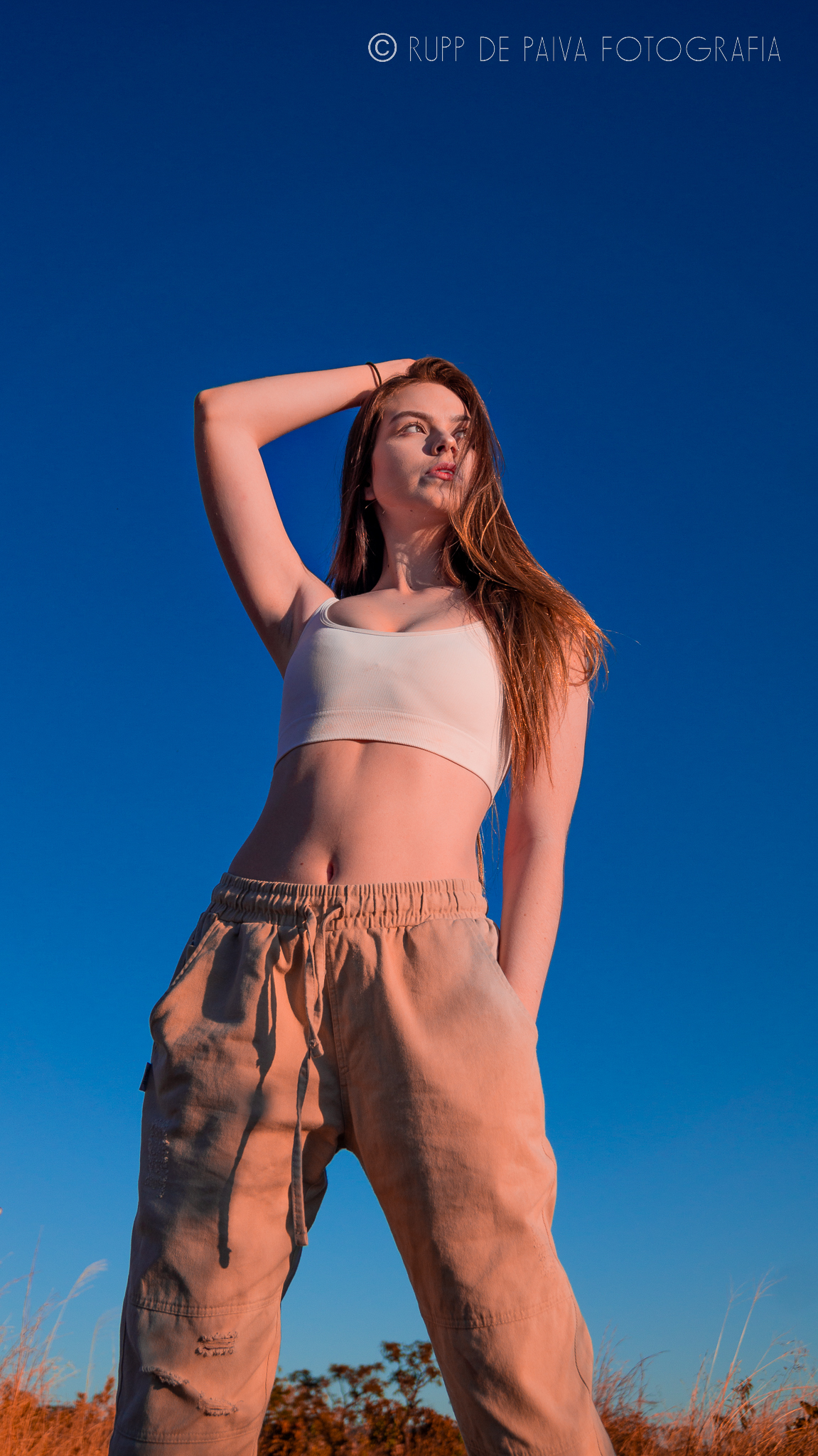 Isabella Moura ao céu azul, corpo para a direita.