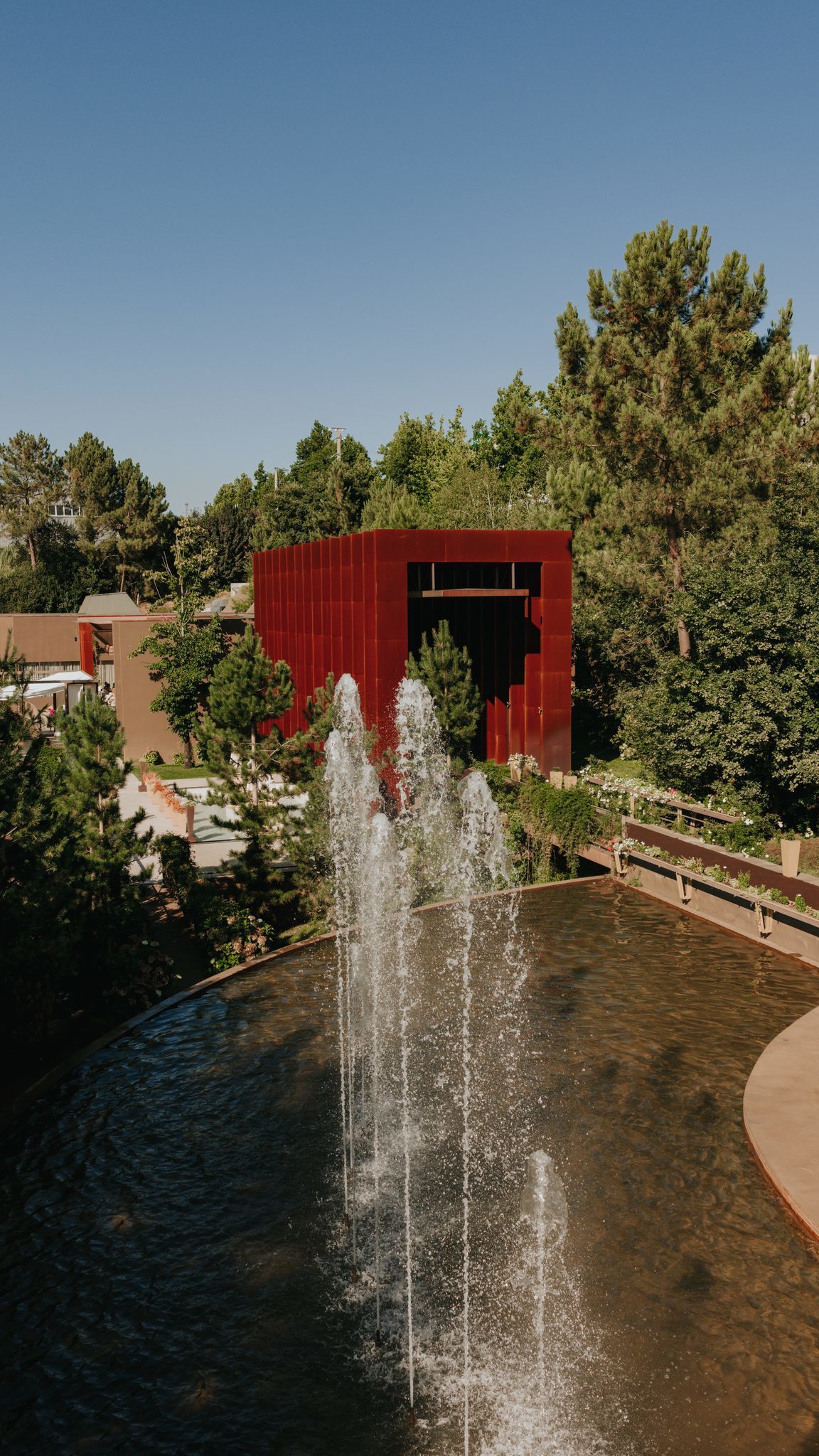 Repuxos no lago com o volume em aço corten ao fundo