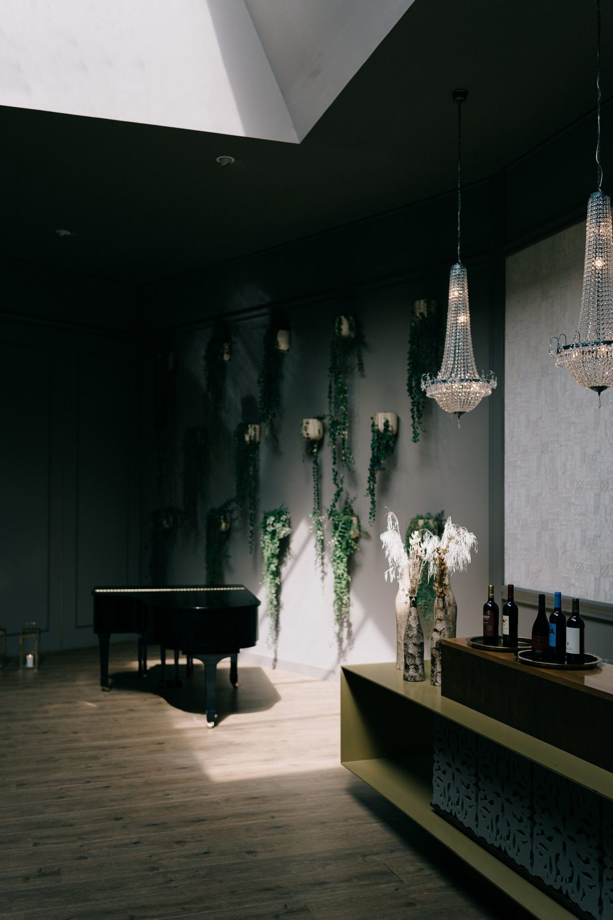 Sala interior com piano de cauda, lustres de cristal e claraboia