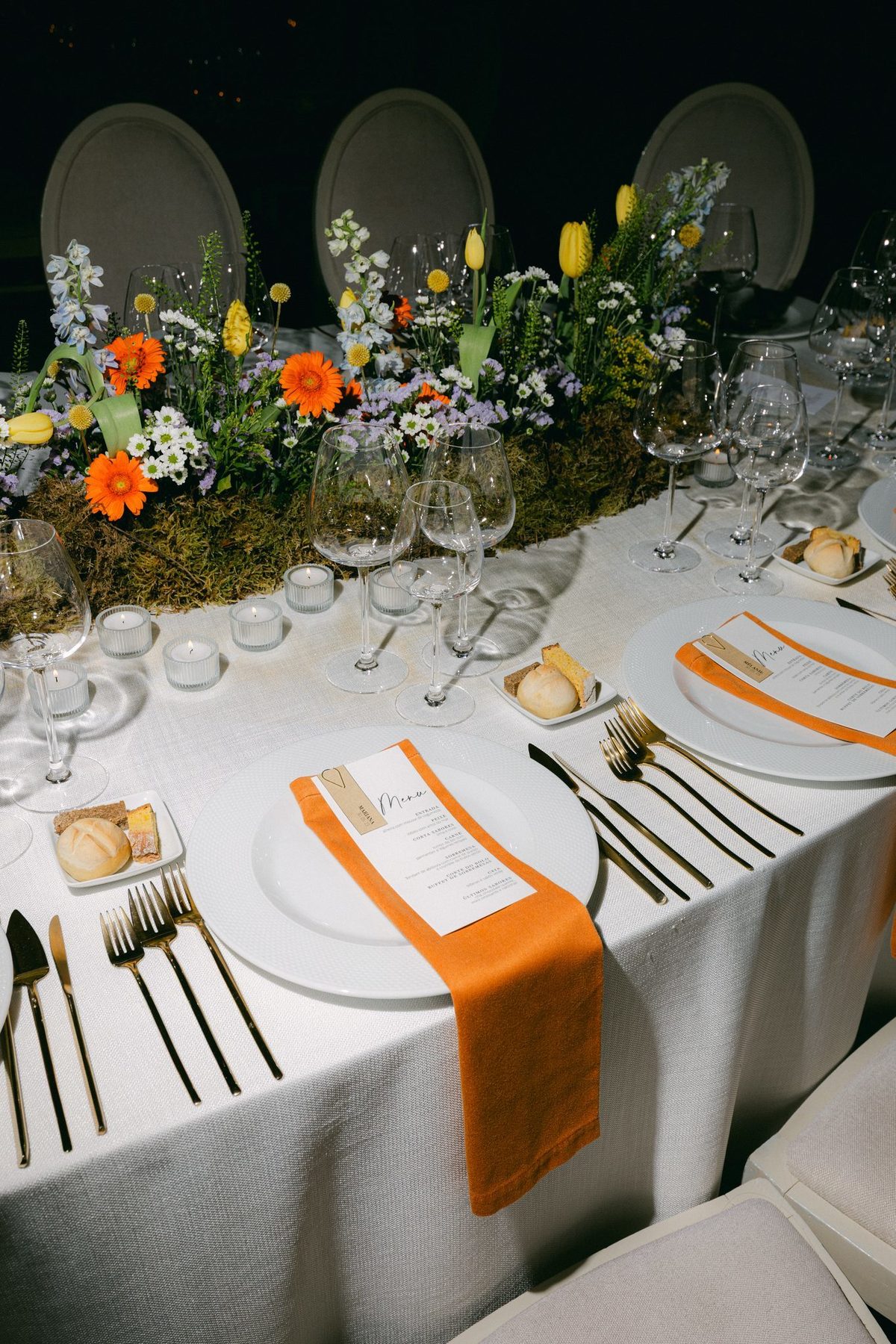 Mesa com flores campestres coloridas e guardanapos laranja