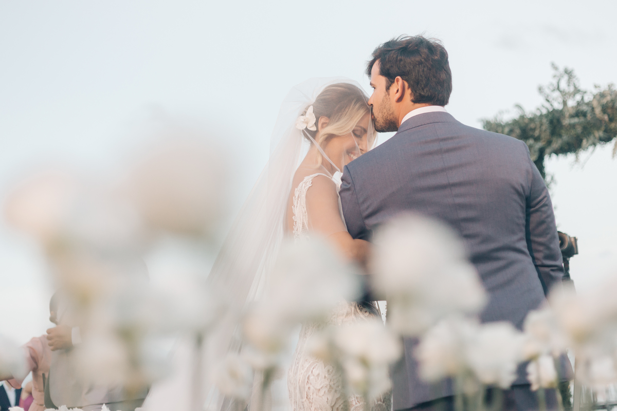 Noivo beijando a testa da noiva.