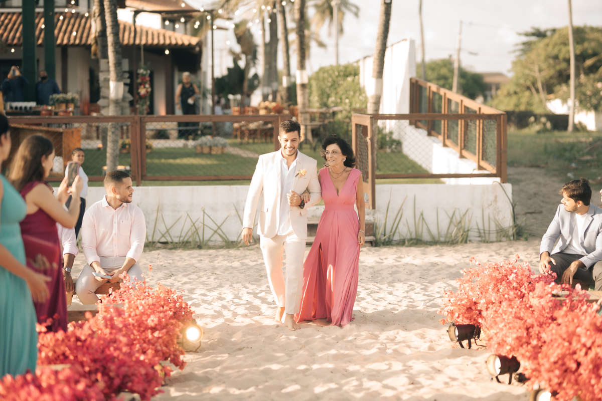 Noivo entrando com pé na areia.