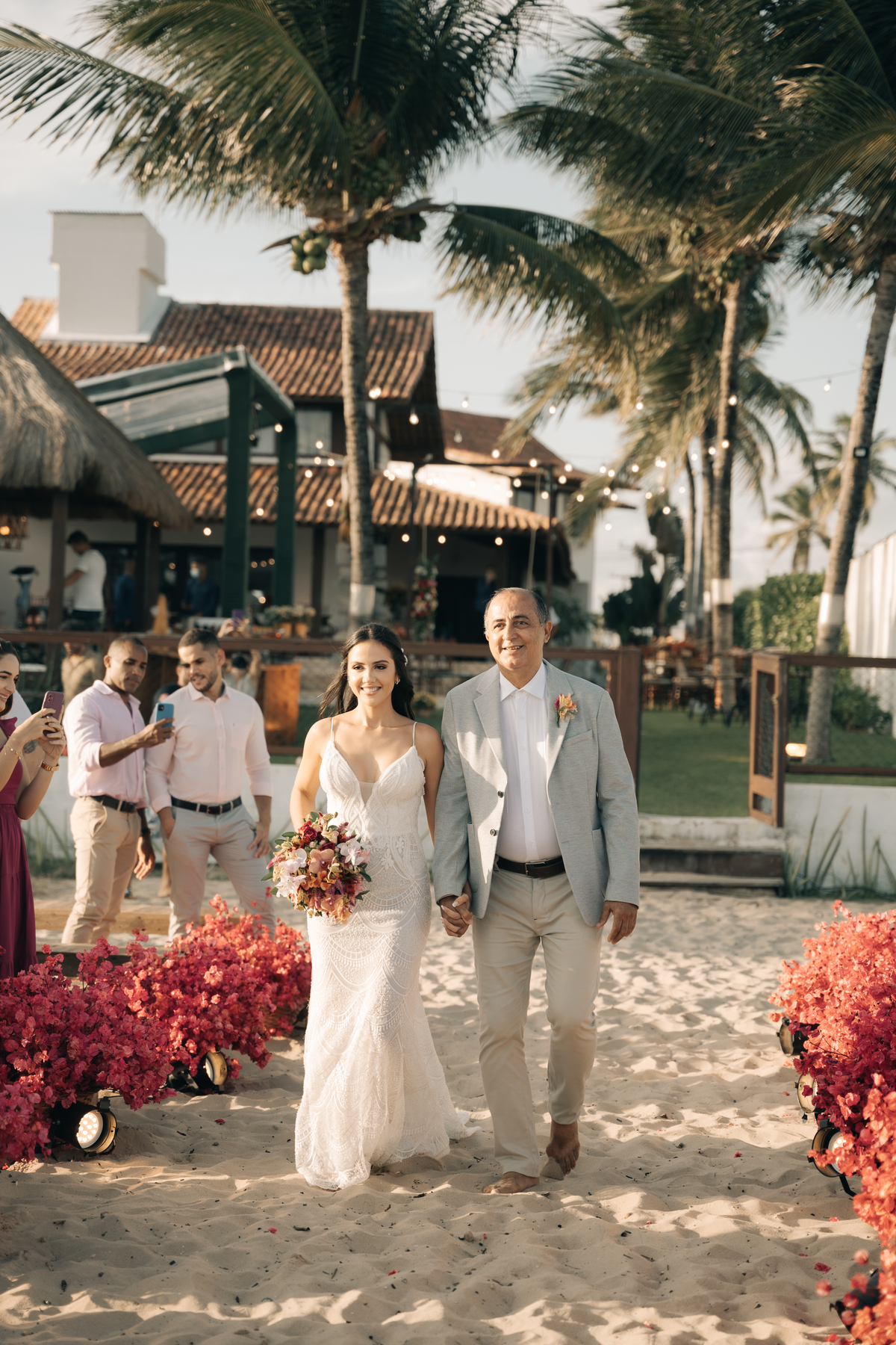 Noiva entrando no seu casamento com um lindo vestido e pé na areia.