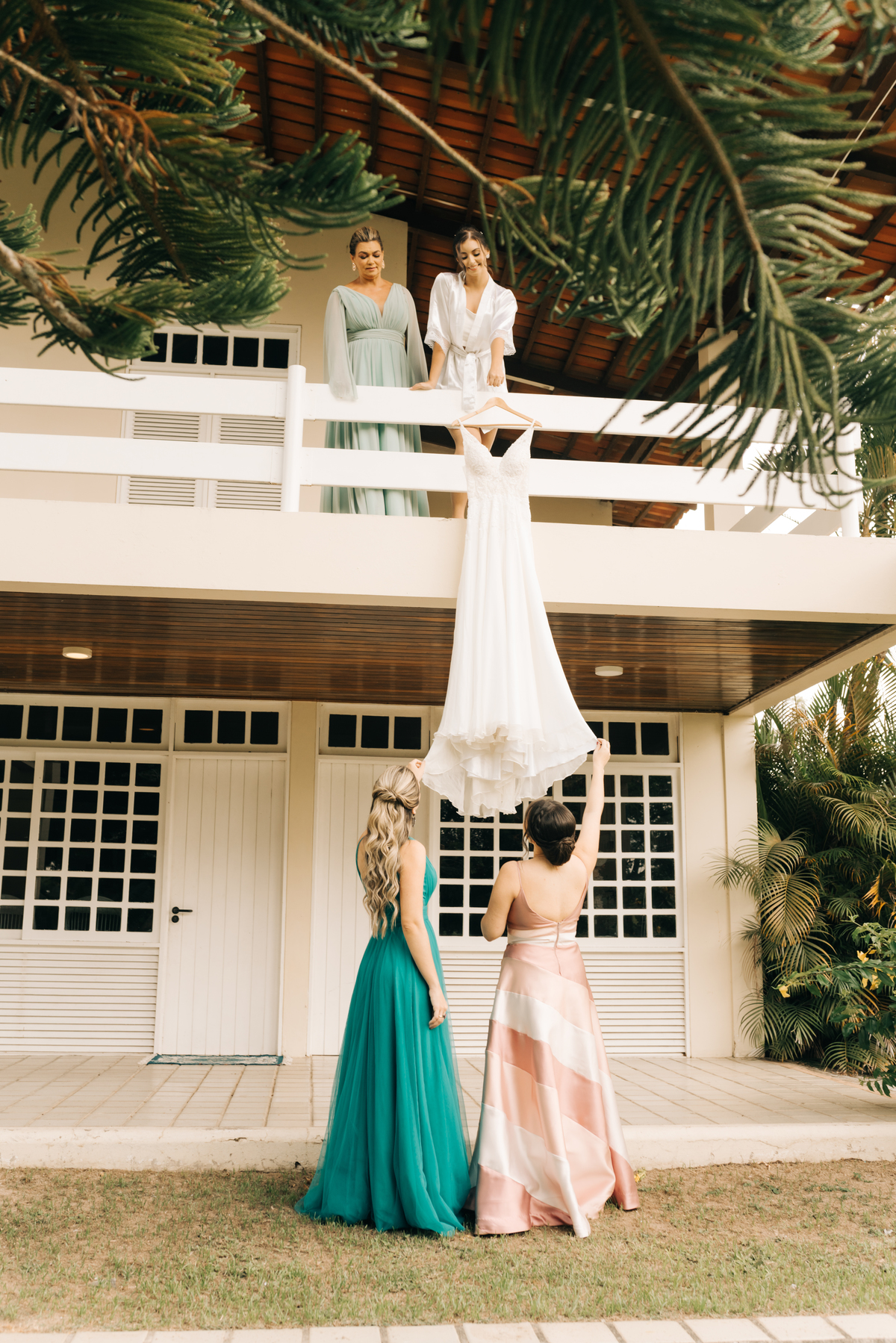 Madrinhas conferindo o vestido junto com a noiva.