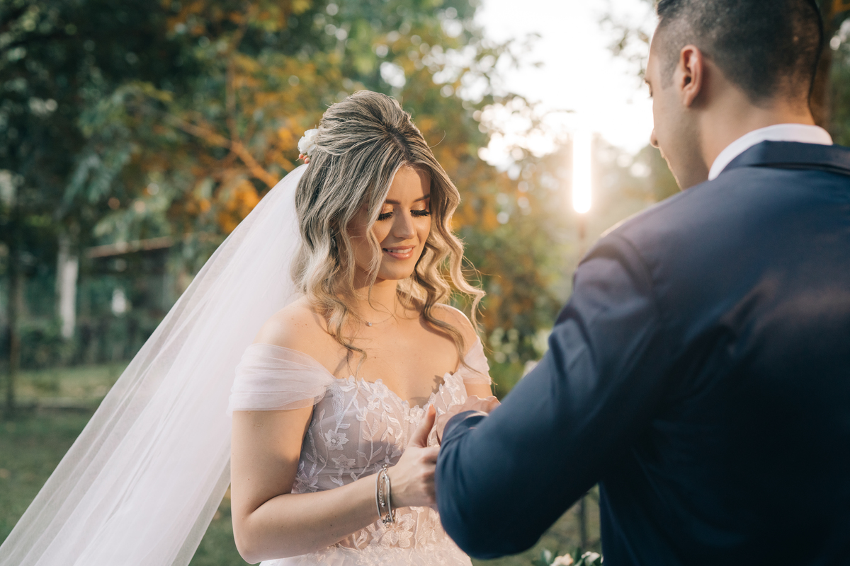 noiva colocando a aliança no noivo.