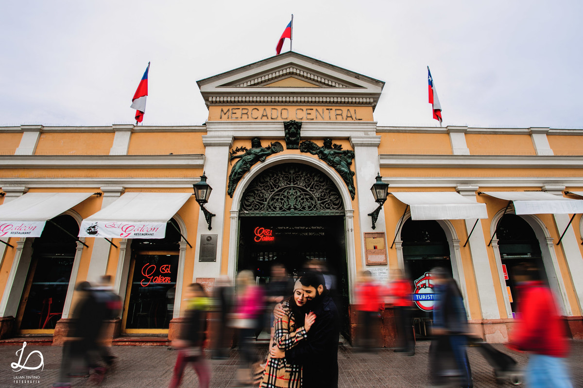 Pessoas passando e o casal se amando, Sérgio e Natalia no ensaio de viagem durante seus dias no Chile. Mercado Central.