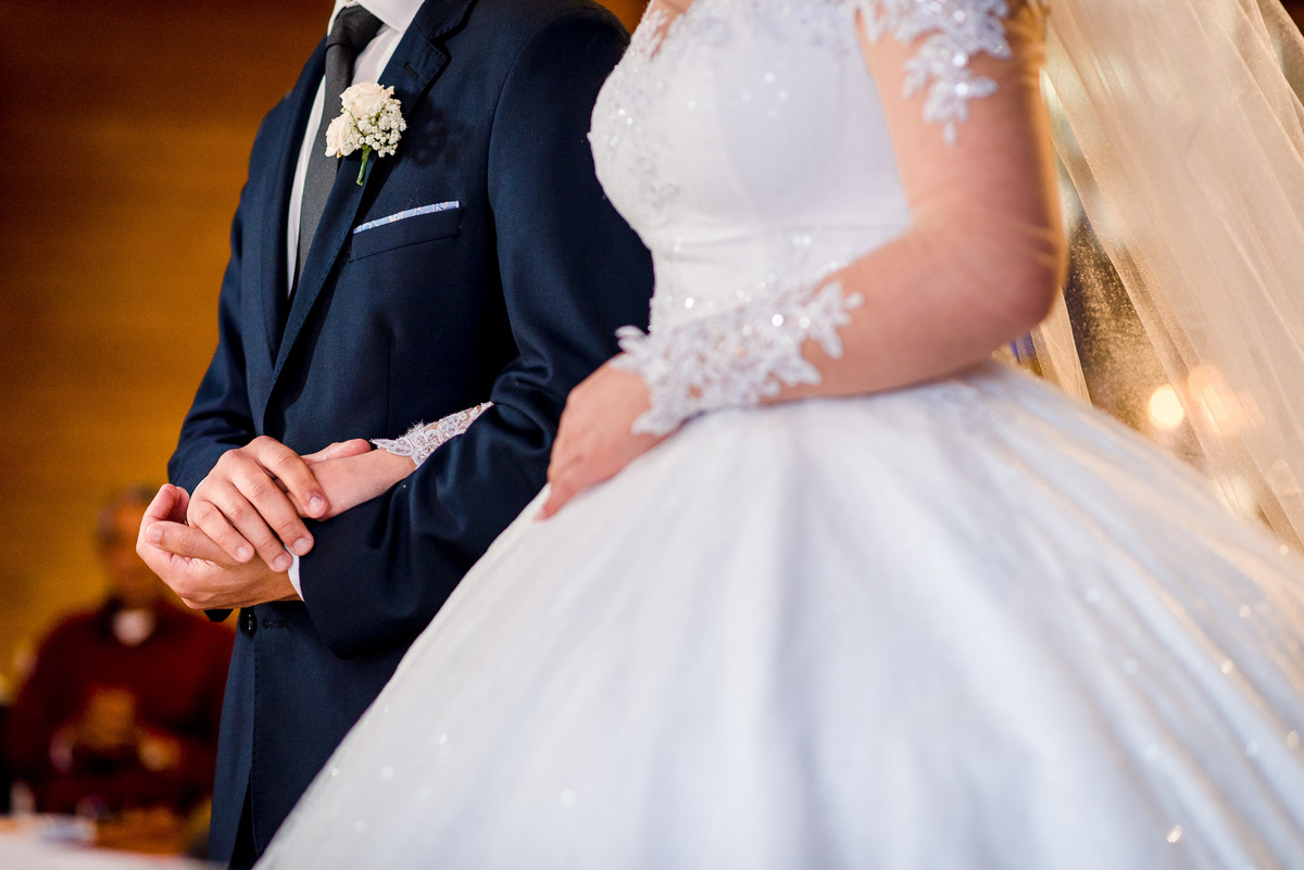 noiva e noivo na cerimônia; noivos de mãos dadas; 