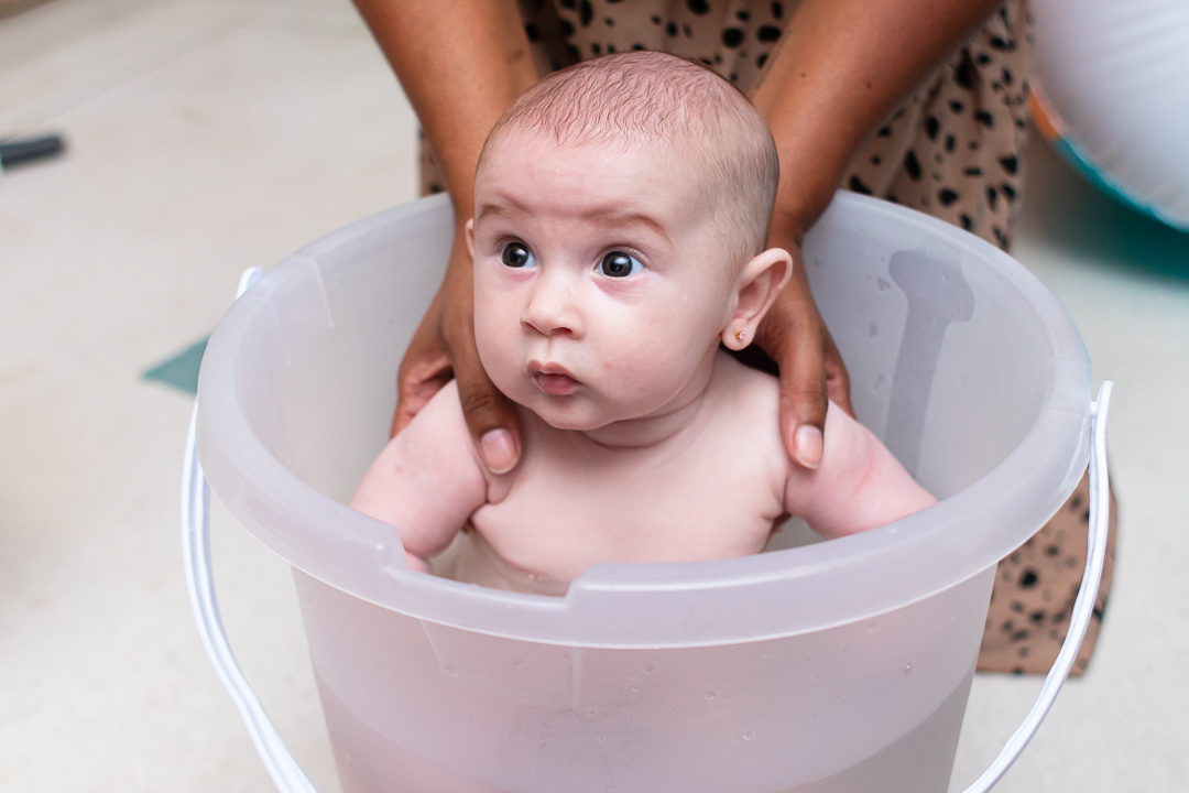 bebe em balde tomando banho de ofurô