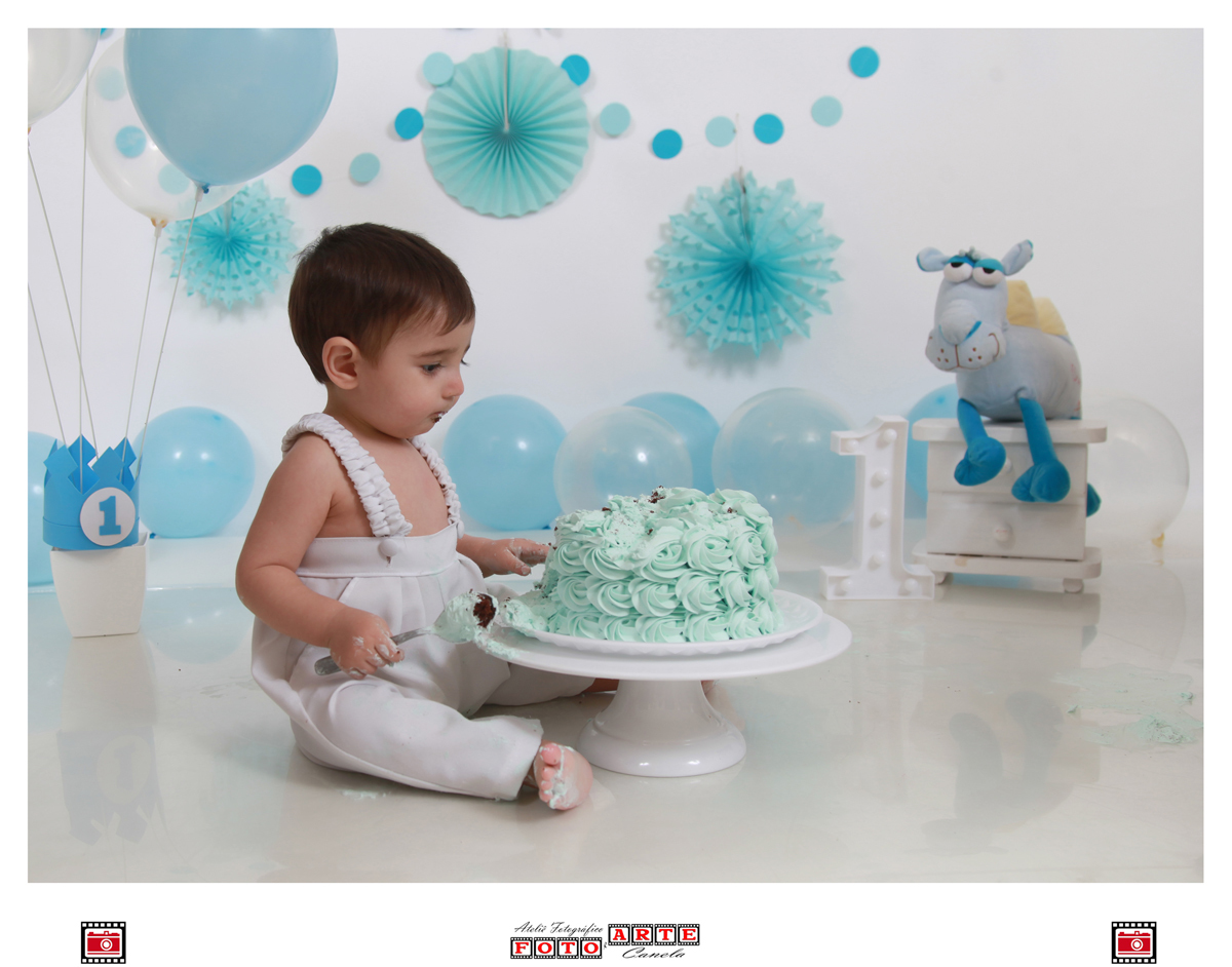 bebê olhando para o bolo em seu ensaio smash the cake