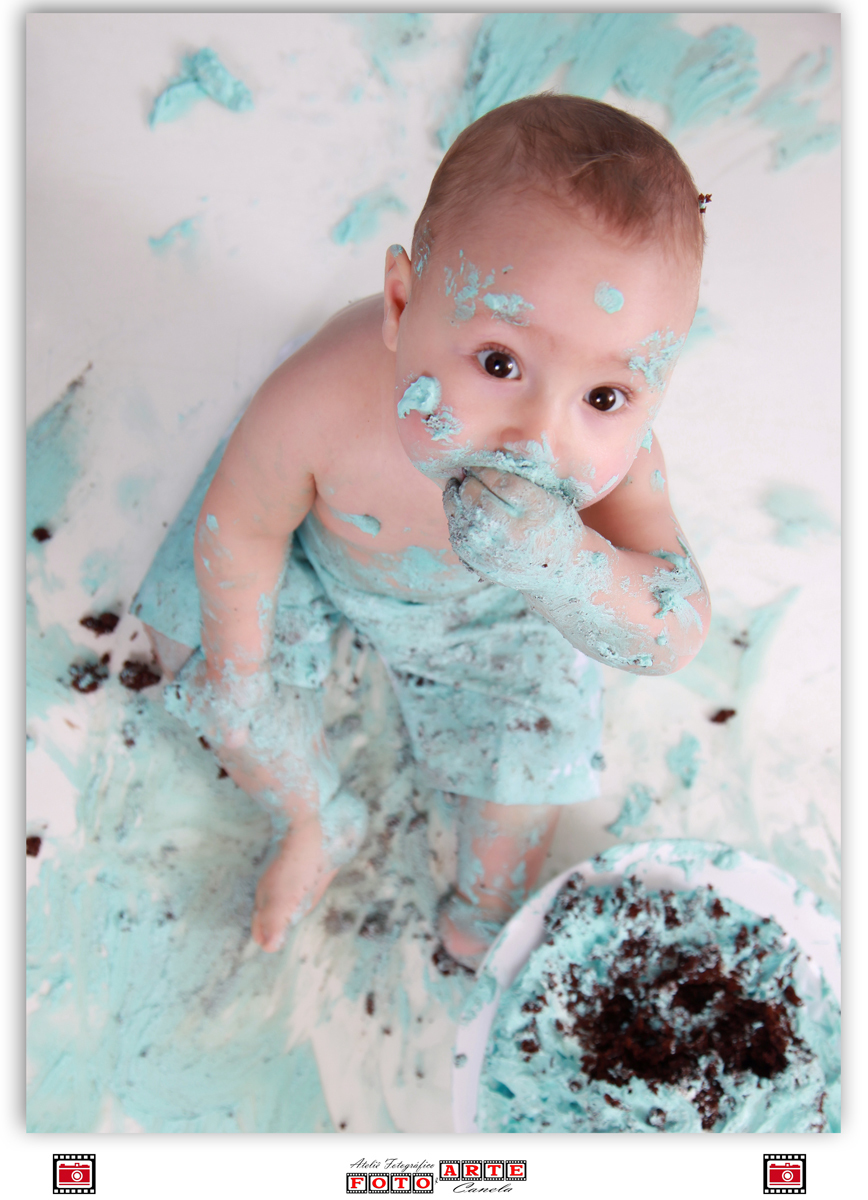 criança comendo bolo azul com a mão