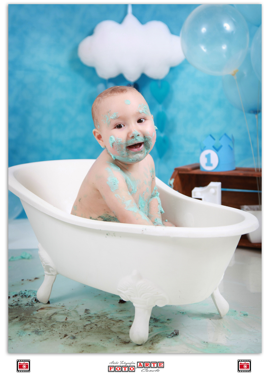 bebê sujo de bolo tomando banho da banheira