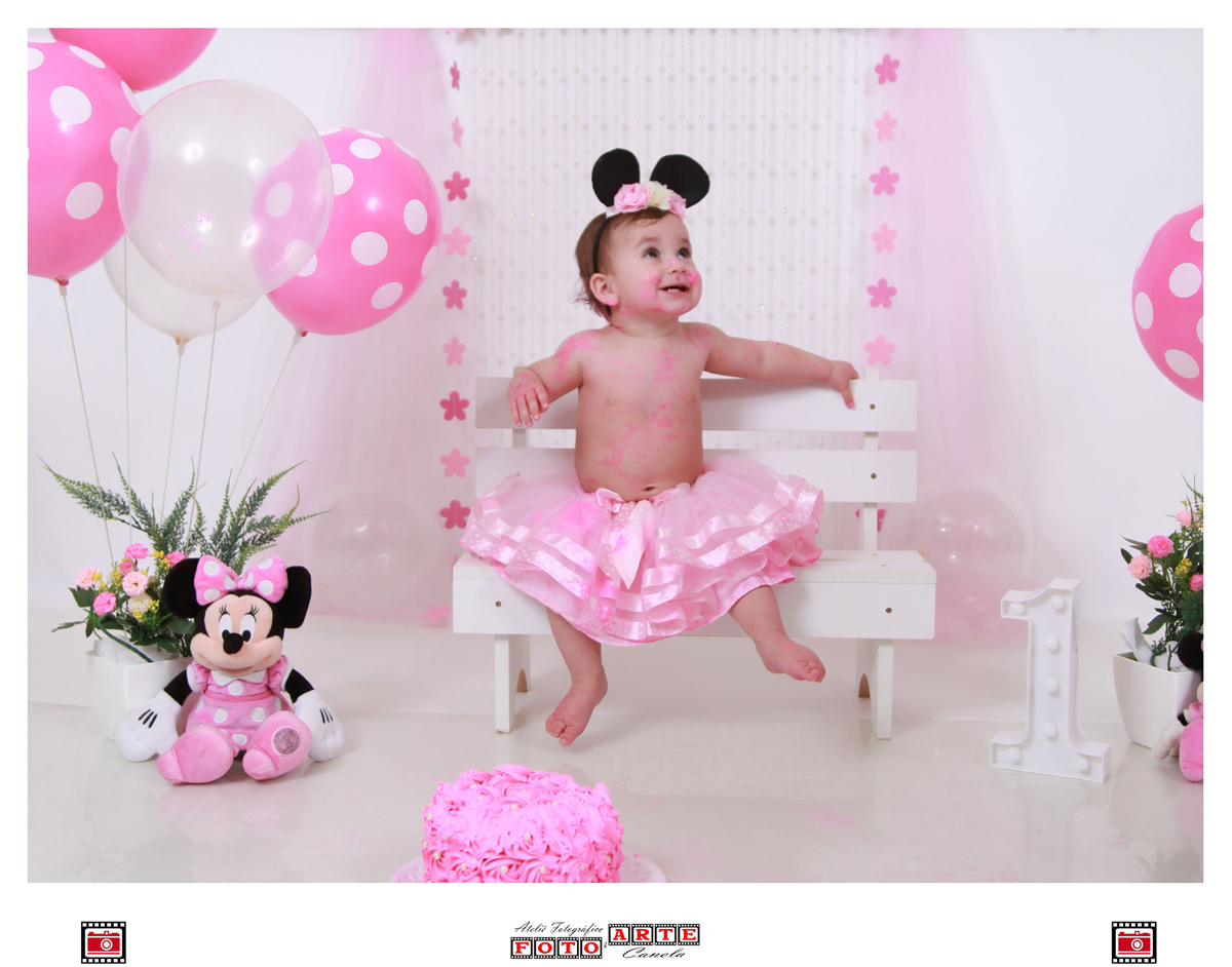 criança sentada em banco com decoração da minnie rosa