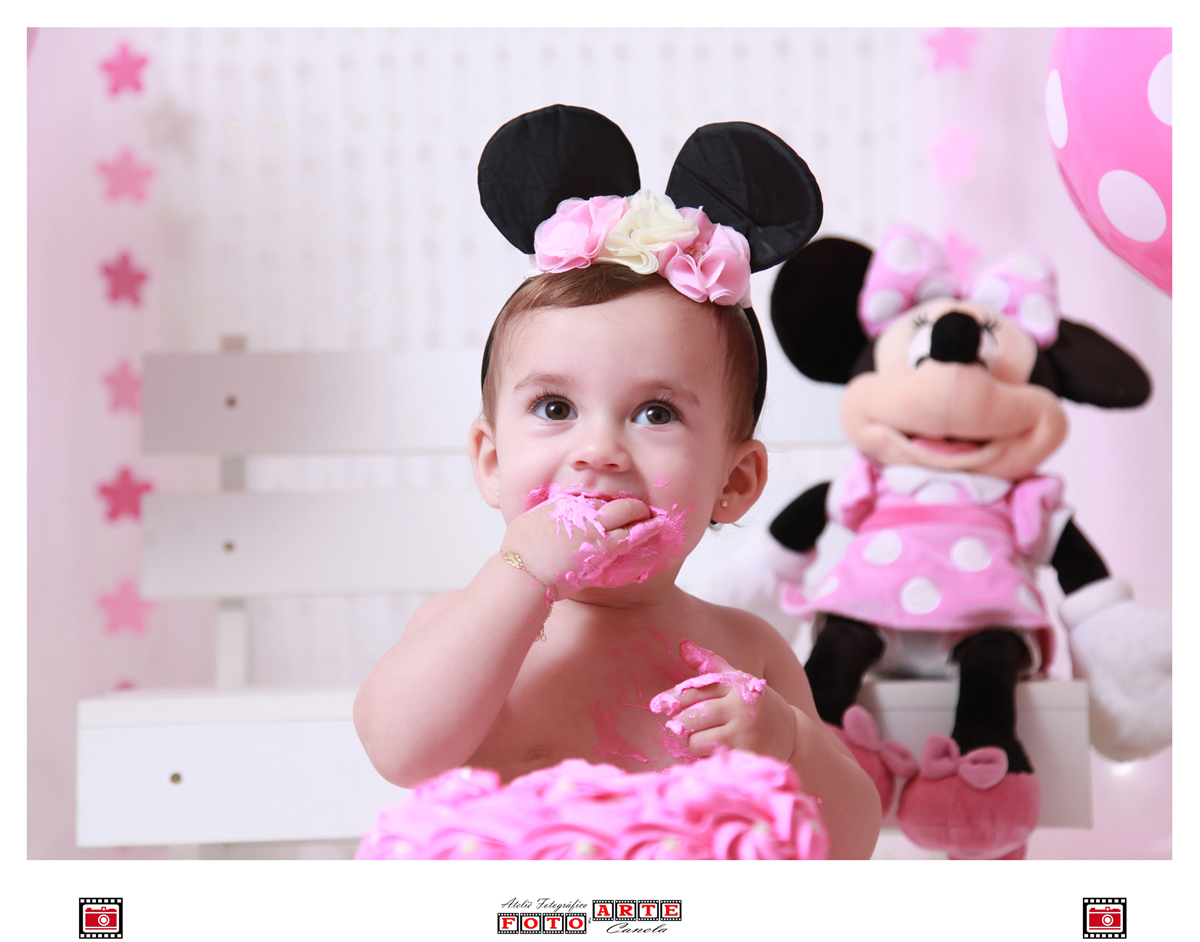 criança comendo bolo da minnie rosa