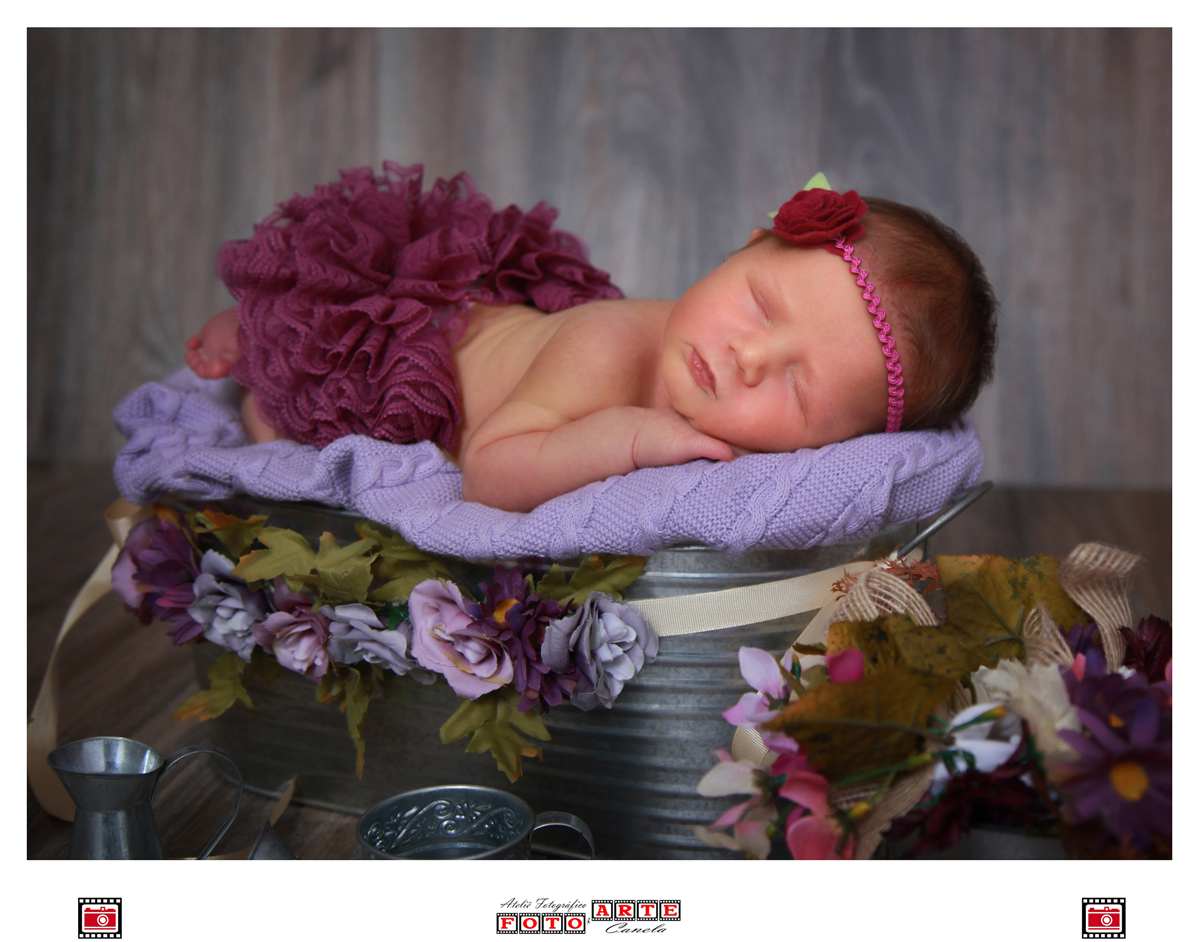 bebê dormindo em cima da mãozinha com flores 