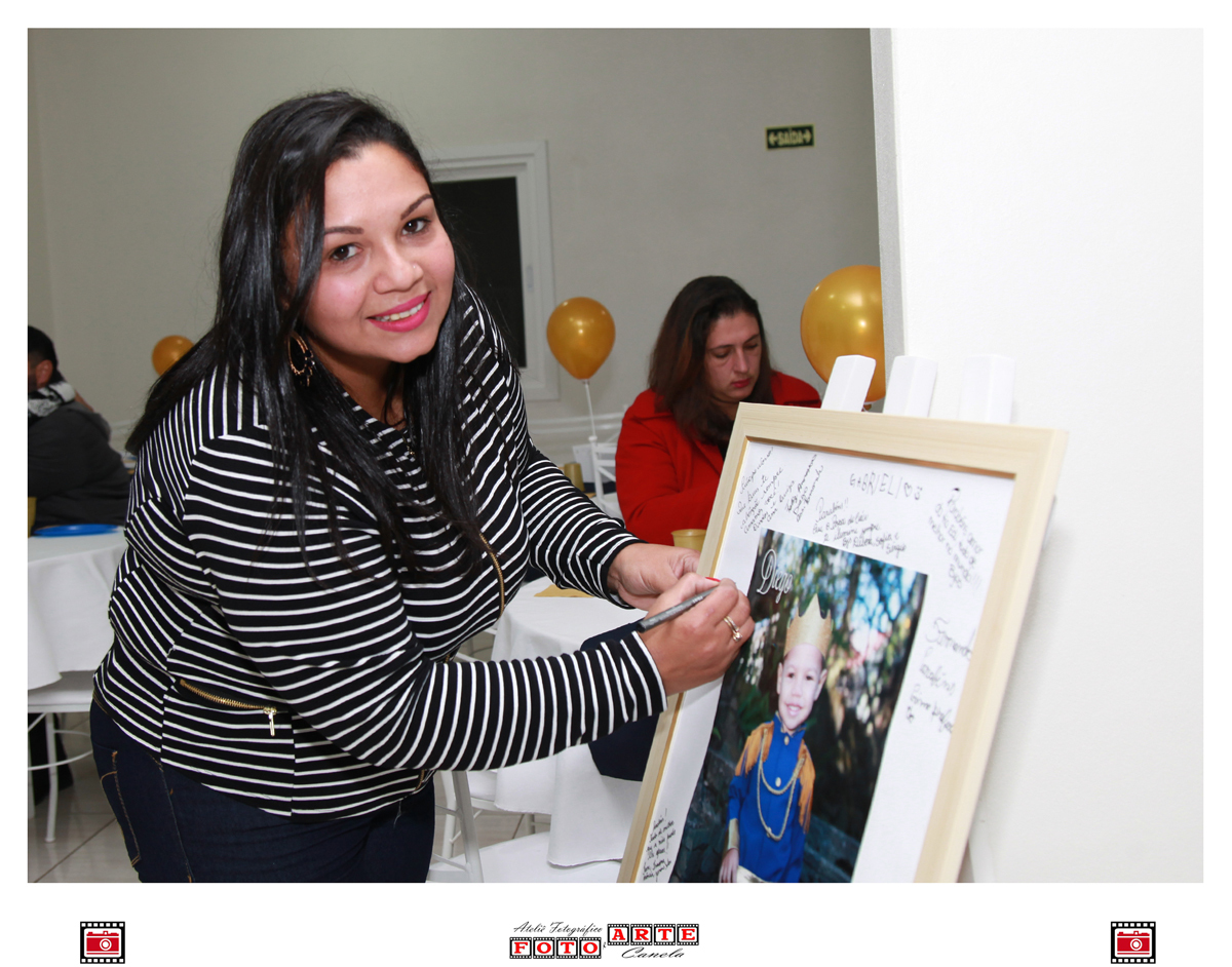 mãe do aniversariante assinando o quadro de assinaturas