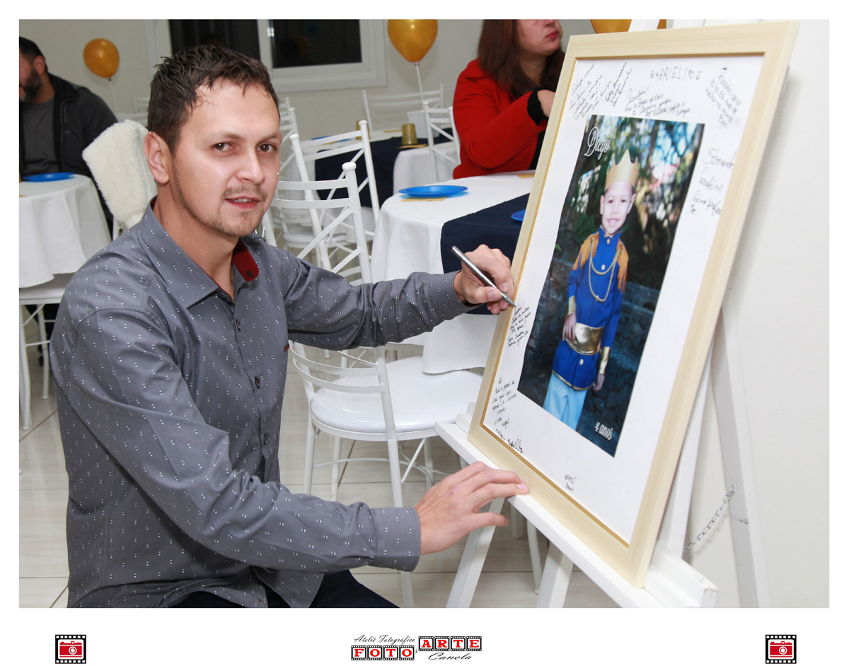 pai do aniversariante assinando o quadro de assinaturas 