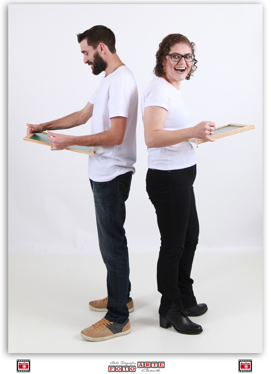 casal de costas um para o outro escrevendo em quadro negro