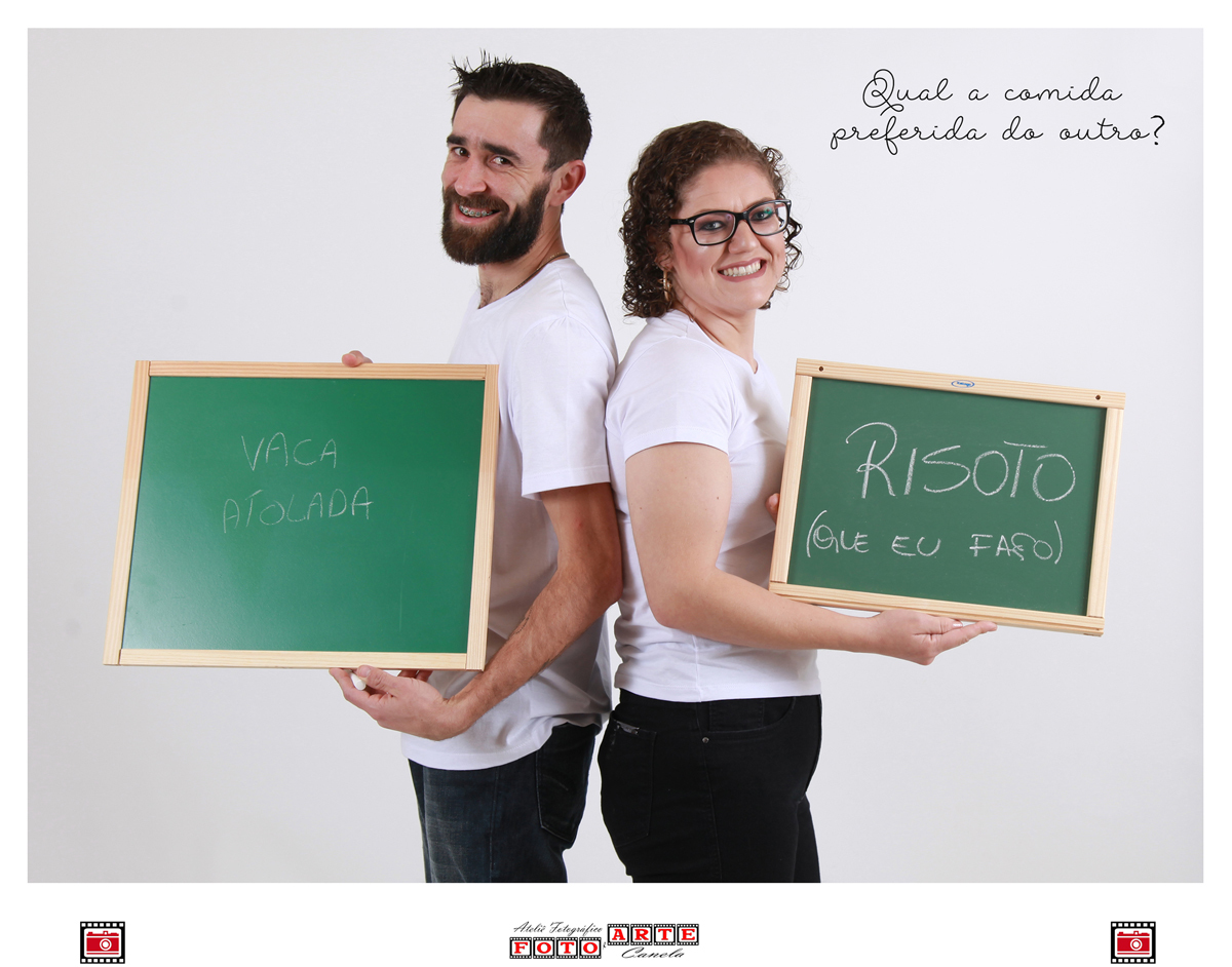 casal mostrando no quadro negro a comida preferida do outro