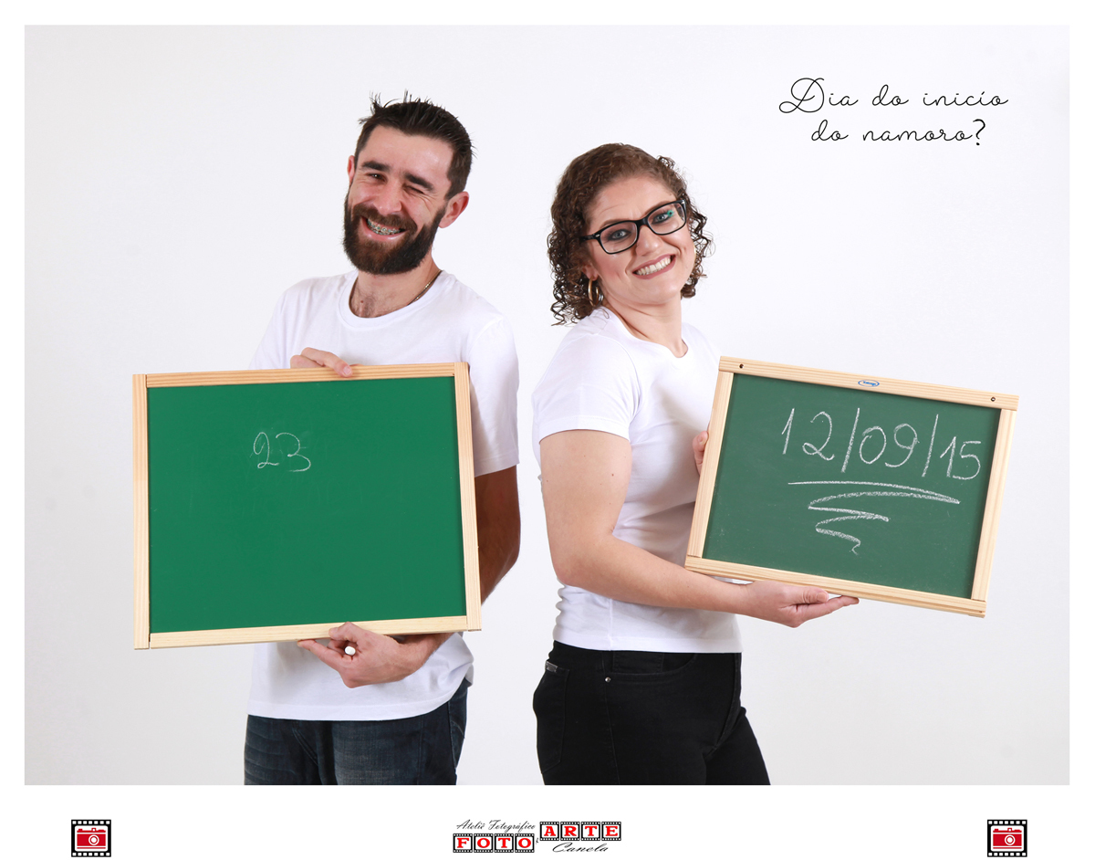 casal mostrando no quadro negro a data do início do namoro