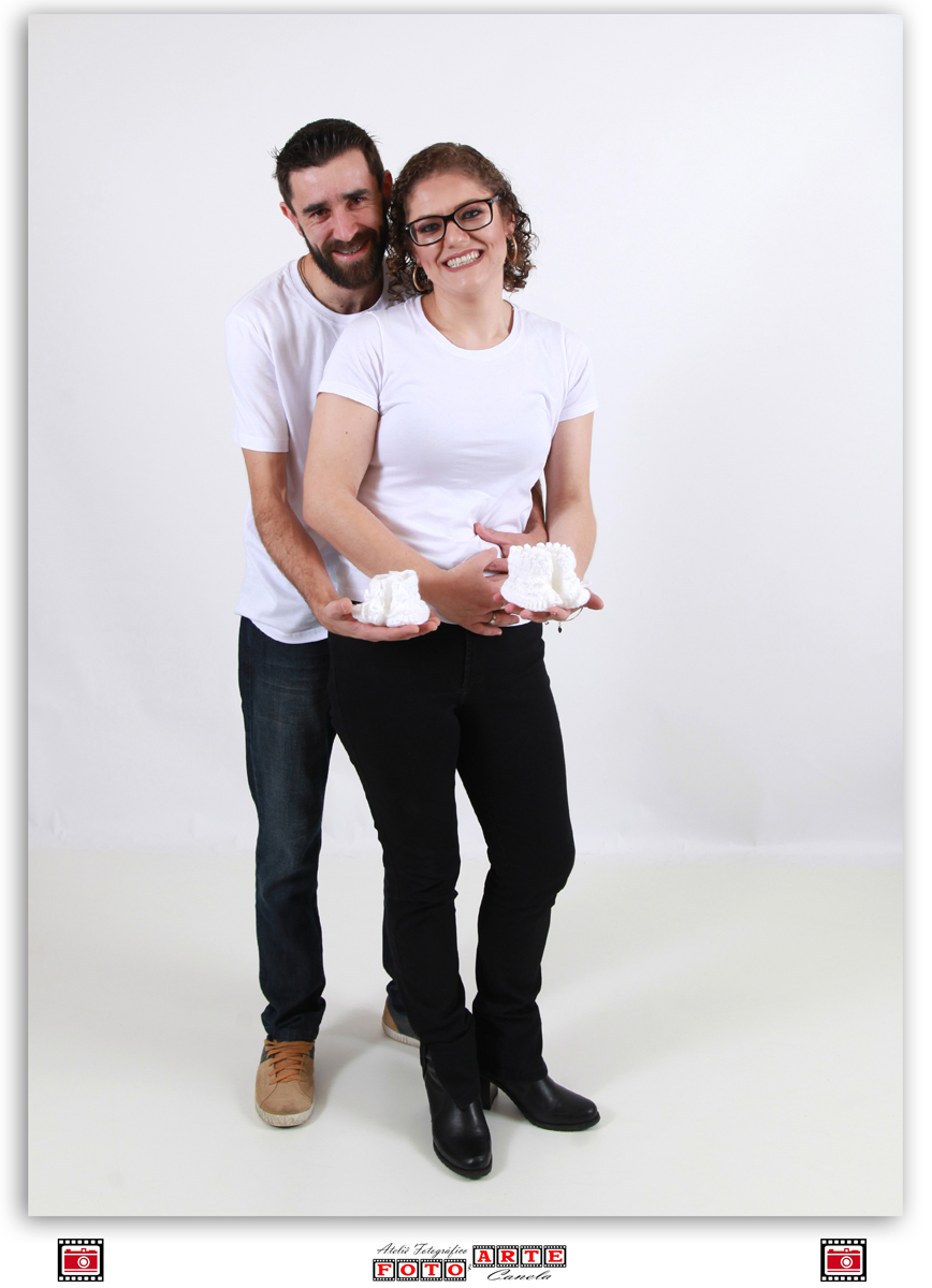 casal segurando sapatinhos brancos de crochê