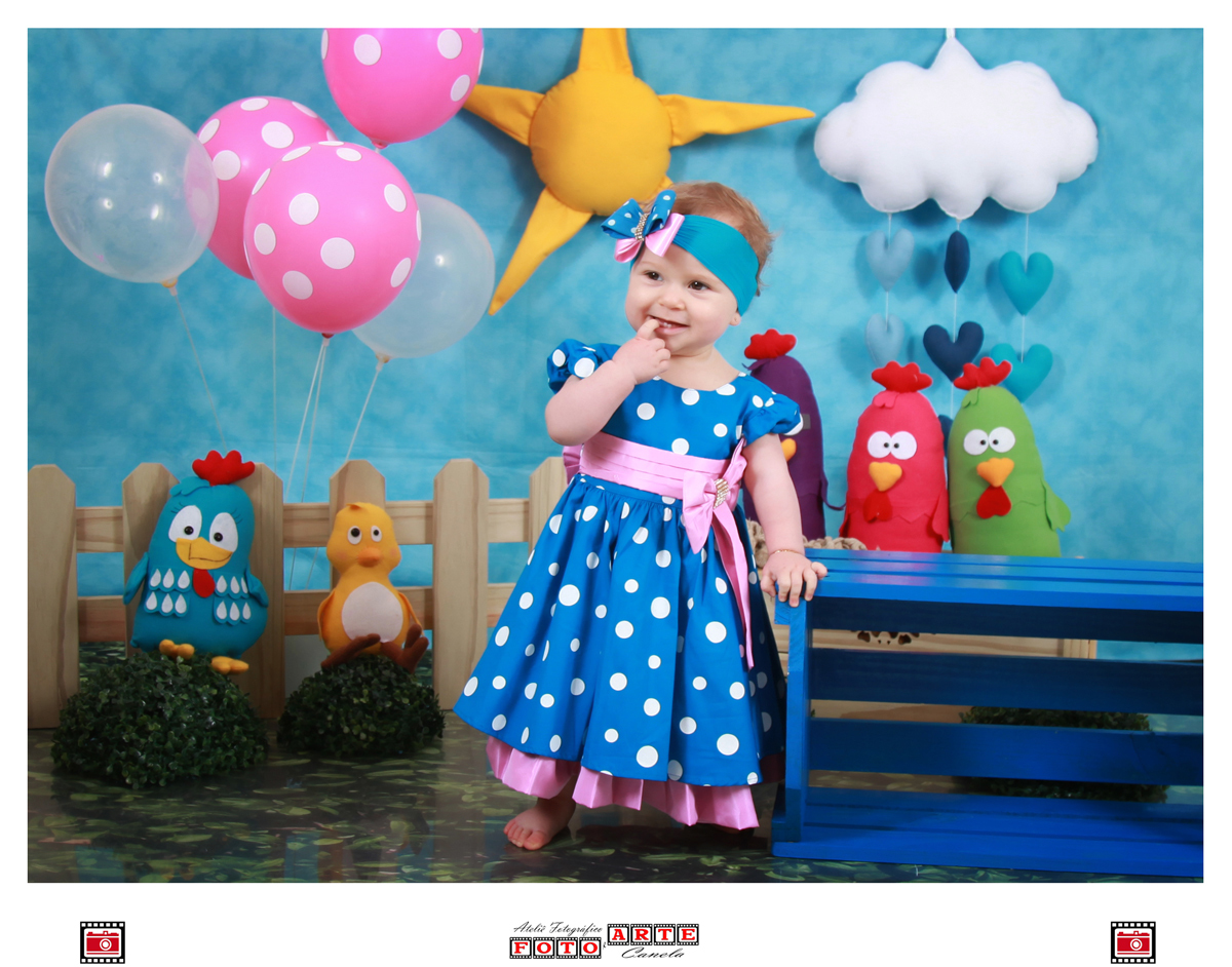 menina em pé no cenário da galinha pintadinha