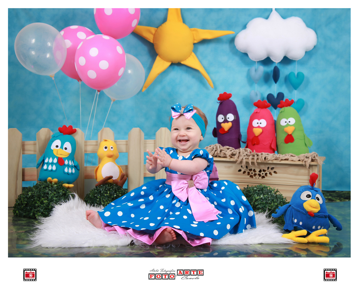 menina sentada e rindo no cenário da galinha pintadinha