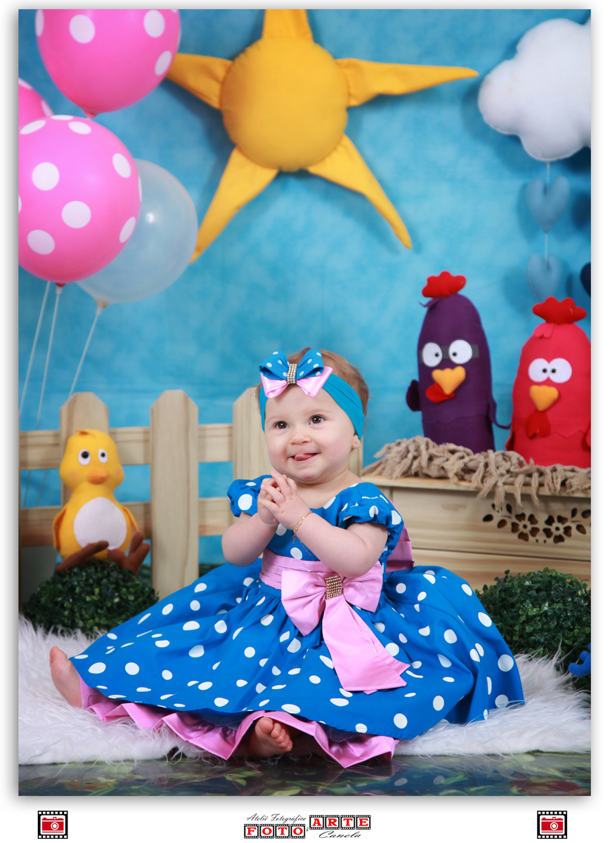 menina mostrando a língua no seu ensaio de um aninho