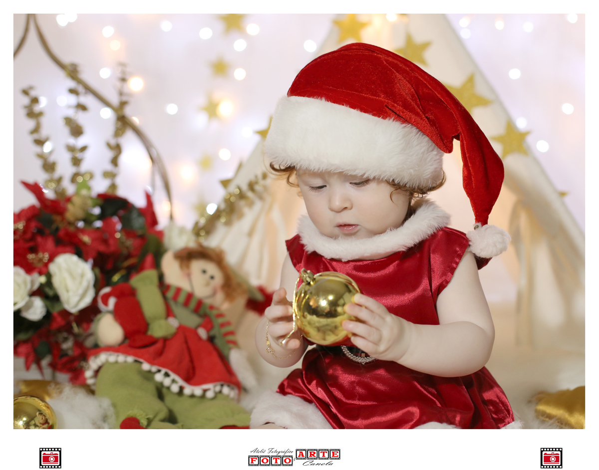criança segurando bolinha de natal