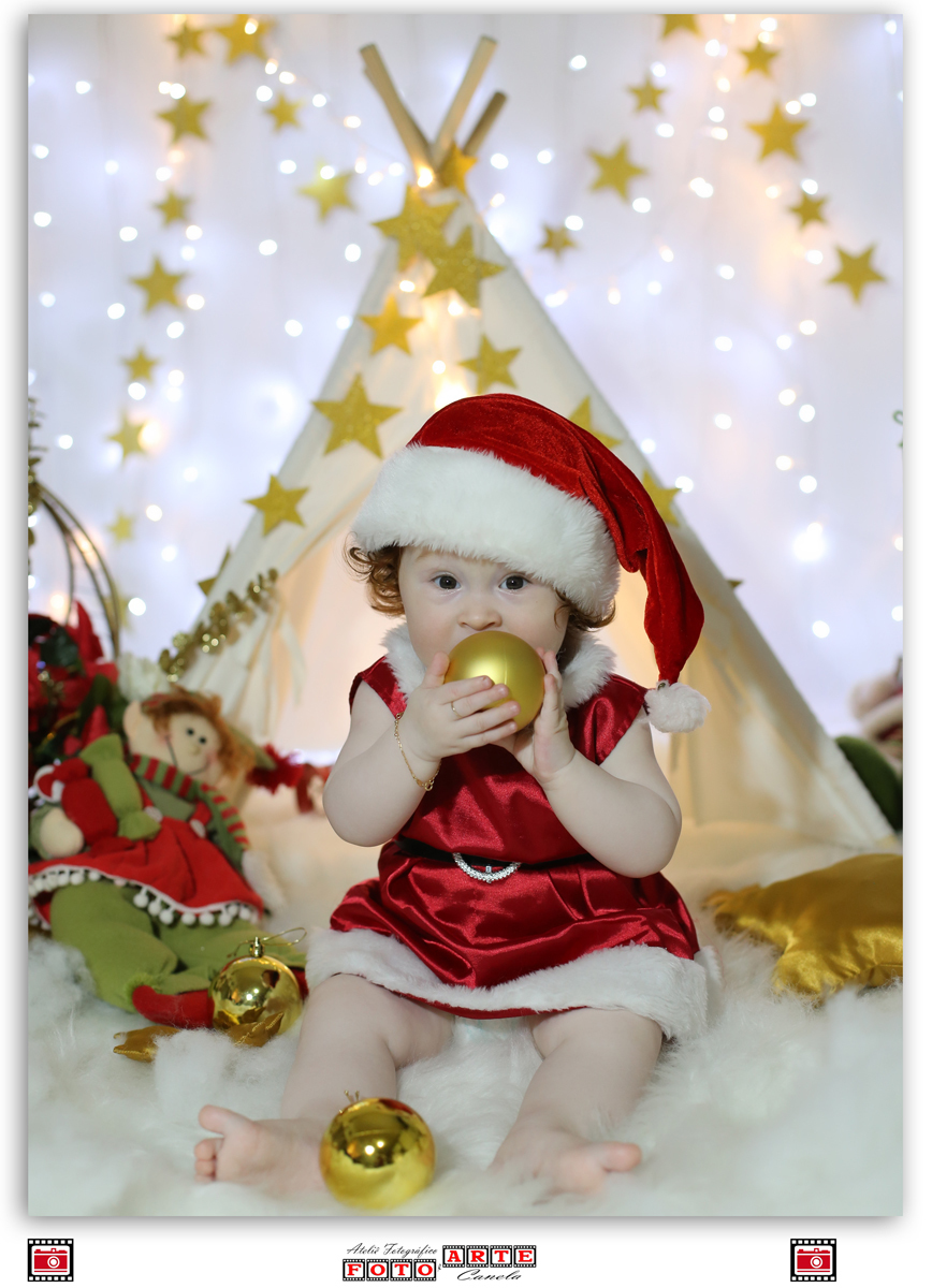 menina mordendo bolinha de Natal