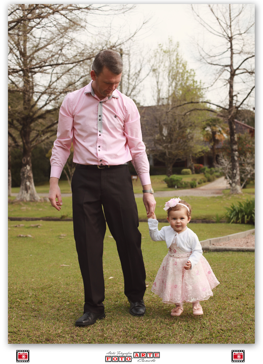 menina de vestido rosa passeando com o pai