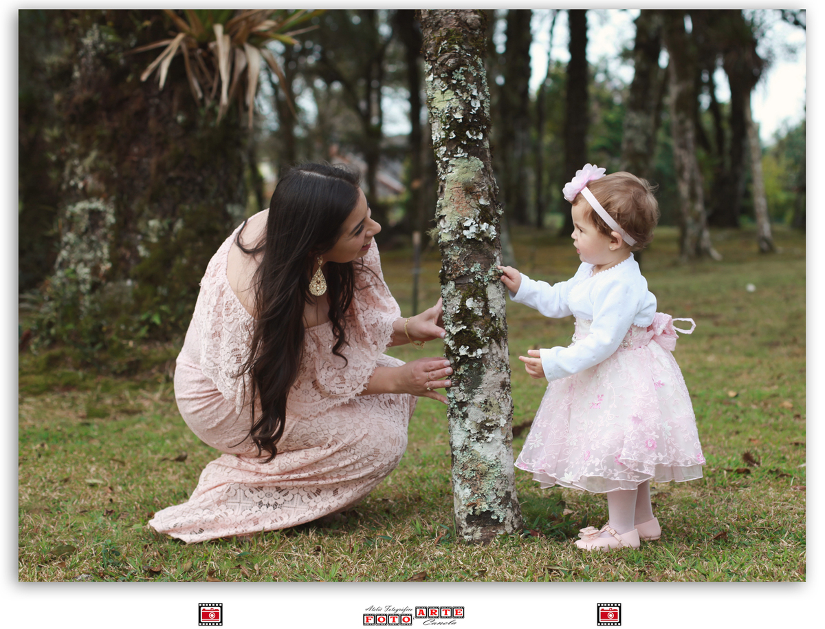mãe e filha brincando na árvore