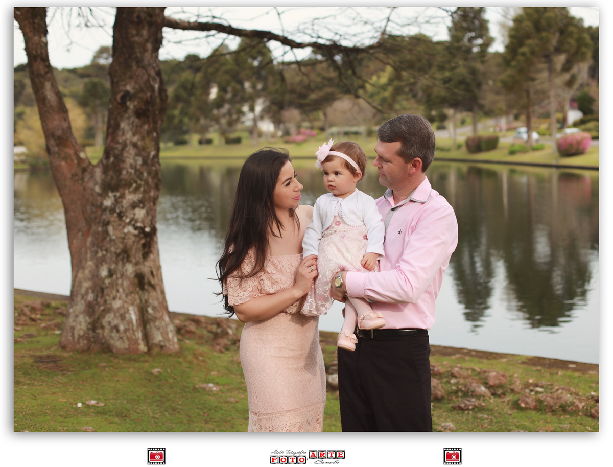 mãe, pai e filha na frente do lago