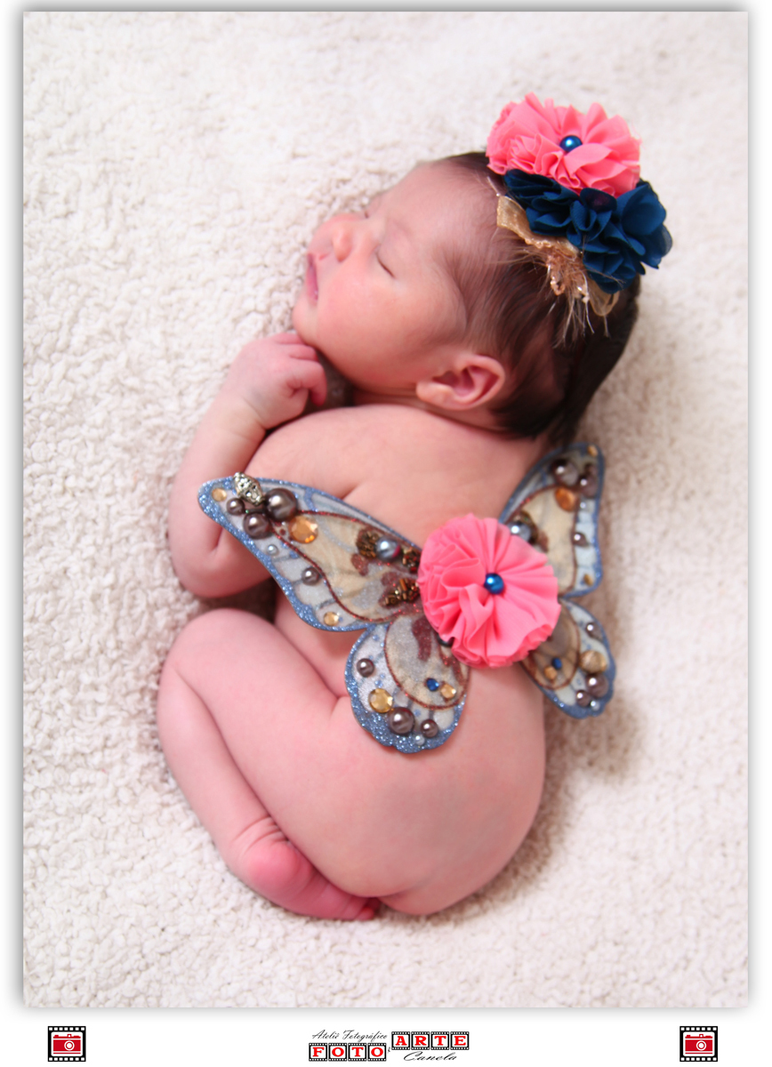 bebê deitado com asinhas de borboleta