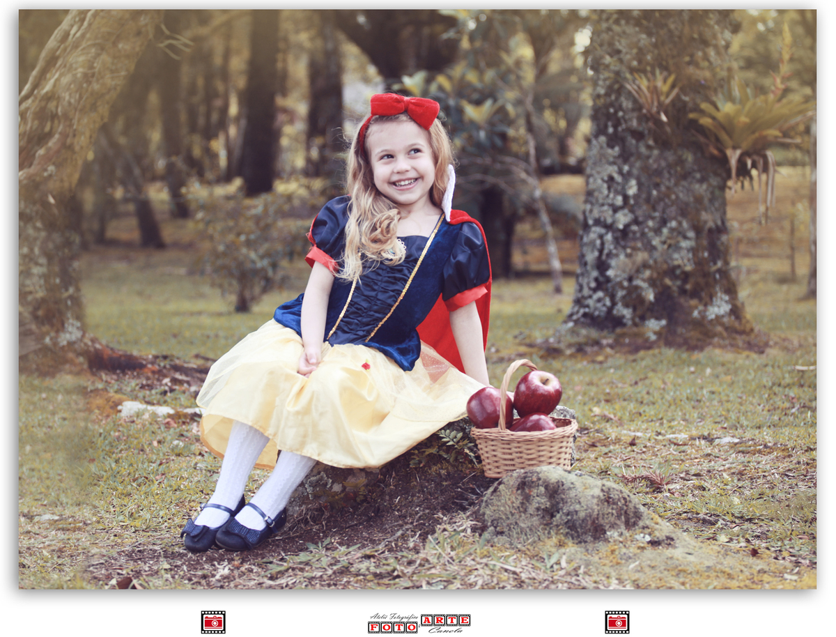 menina vestida de branca de neve sentada com uma cesta de maçãs ao 