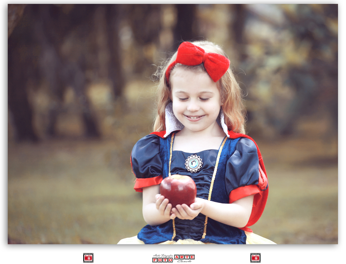 menina vestida de branca de neve olhando para maçã