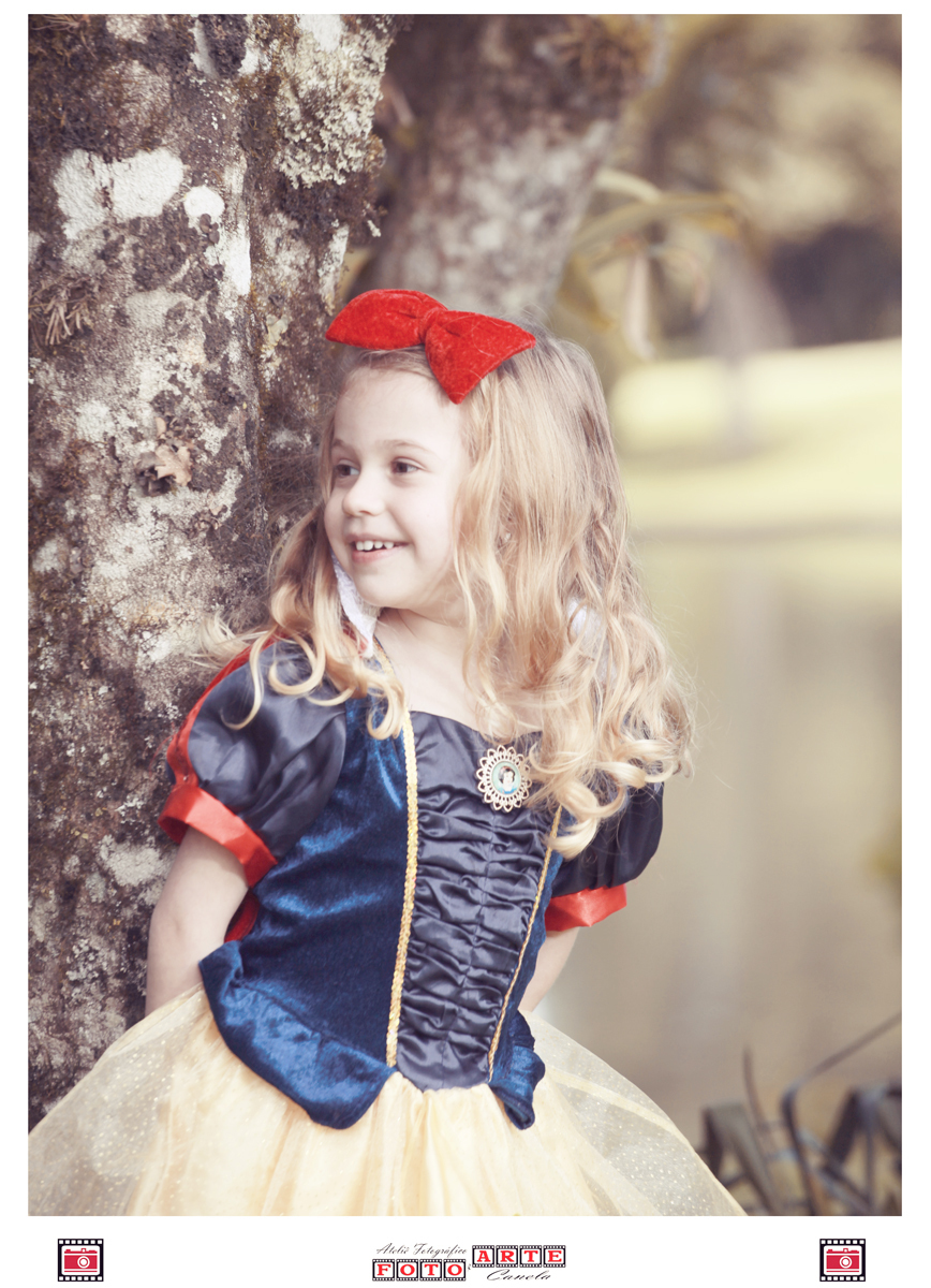 menina olhando para o lado sorridente com fantasia da branca de neve