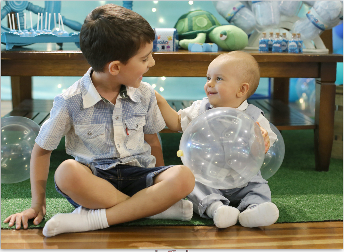 irmãos sorrindo e brincando com balão