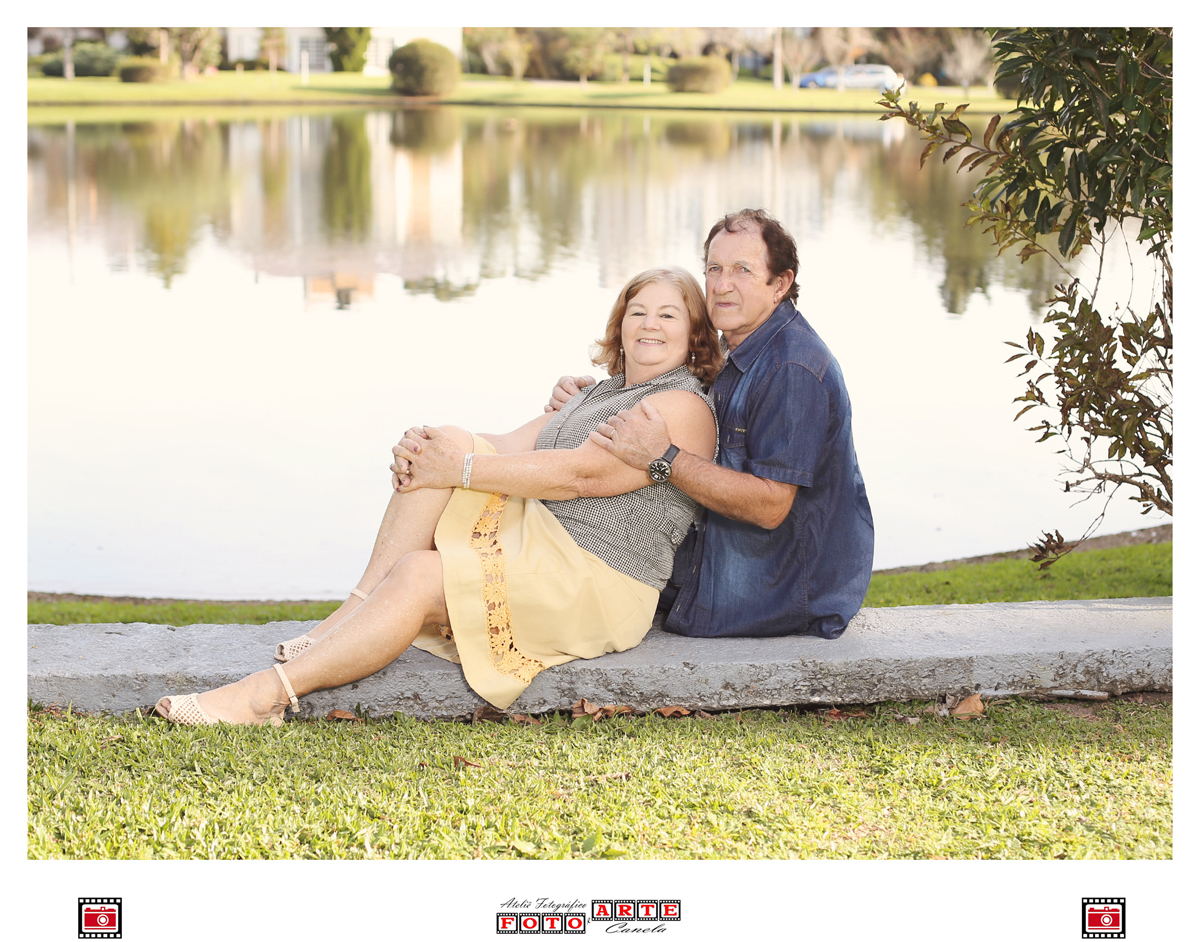 casal sentado a beira do lago