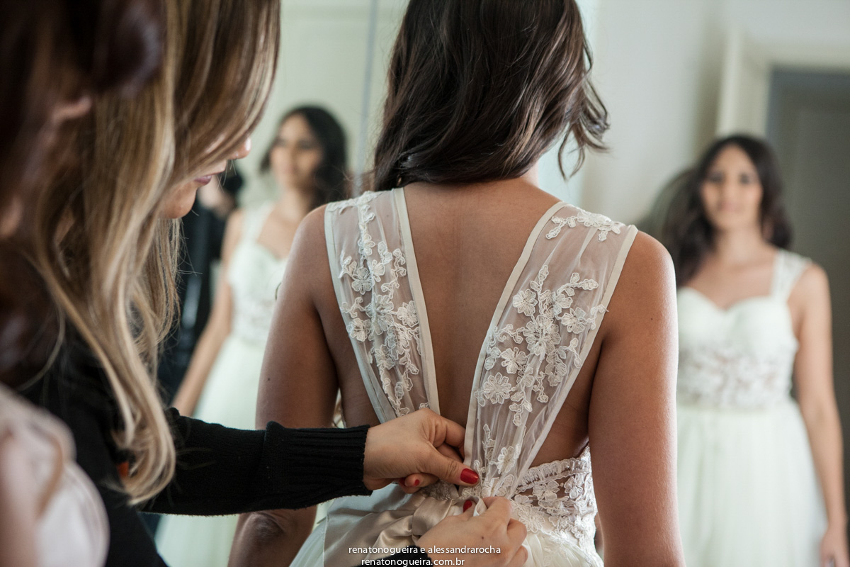 fechando o vestido da noiva para o grande momneto do casamento