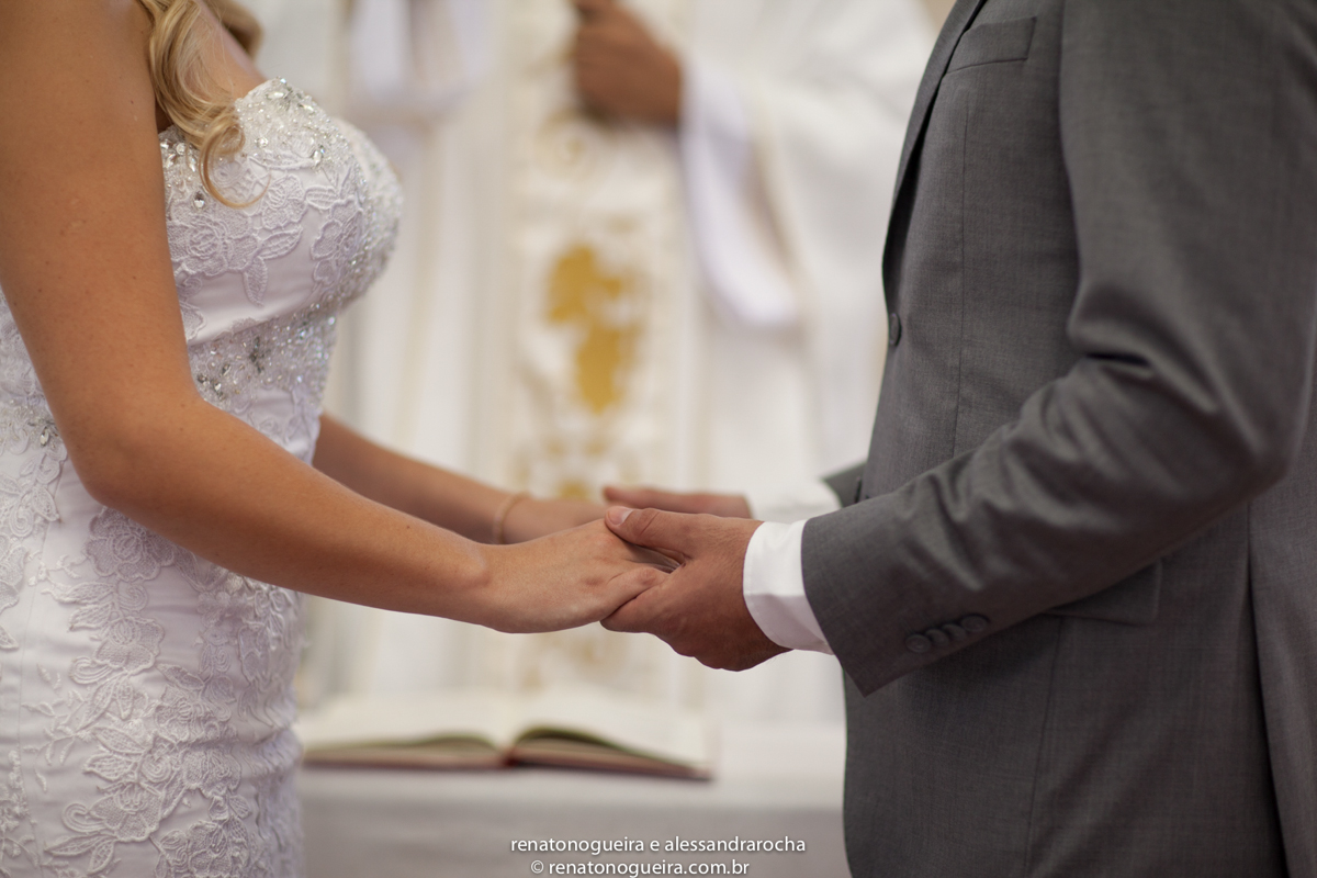 detalhe dos noivos de maos dadas na igreja no momneto da bencao