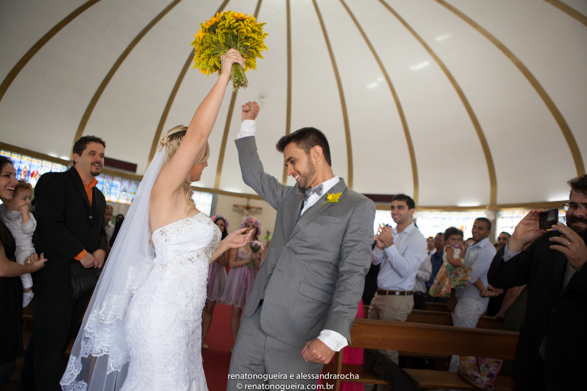 noivos comemorando a uniao na porta da igreja