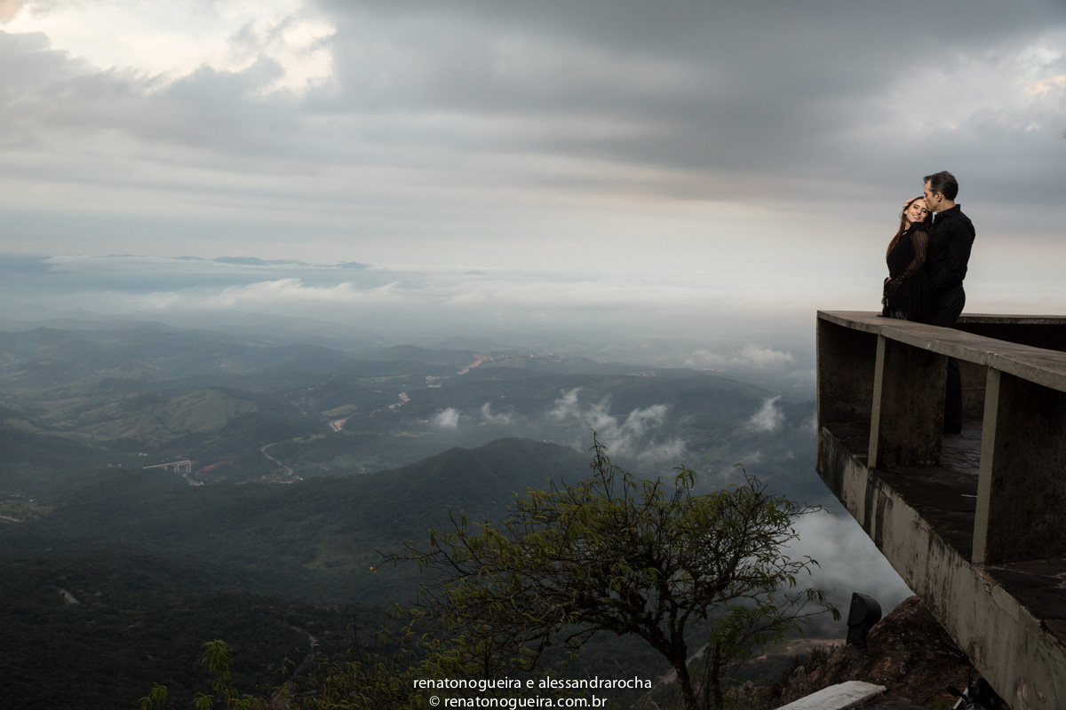 noivos no mirante da serra da piedade, com uma paisagem linda no fundo das serras de minas gerais