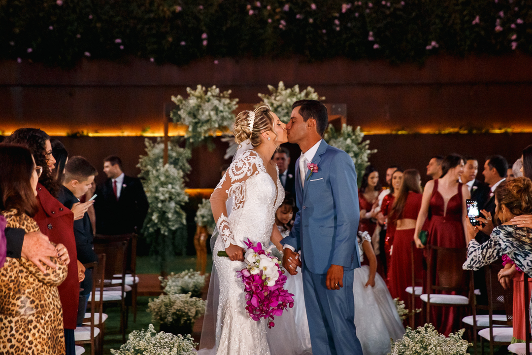 noivos beijando na saída da cerimônia