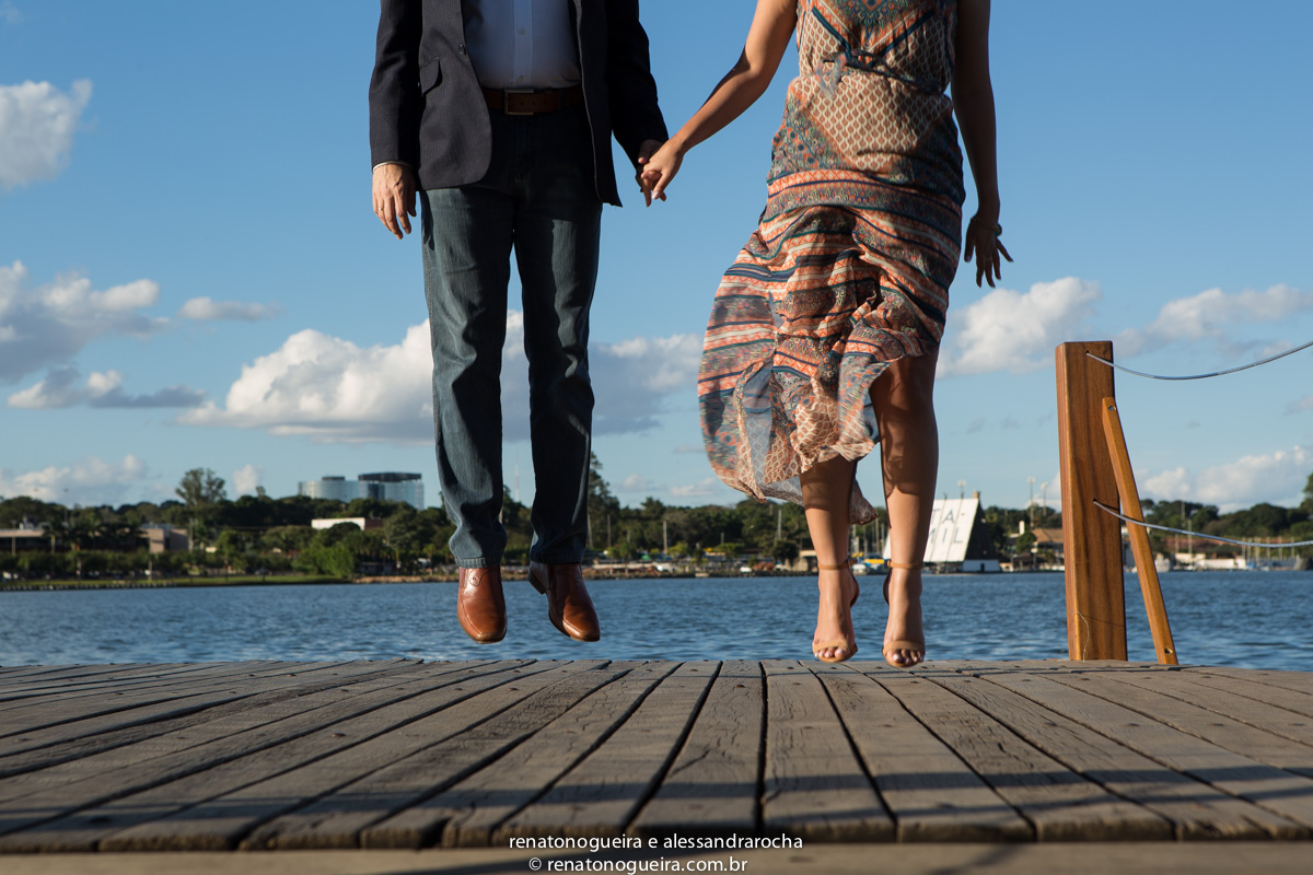 casal saltando no cais em expressao de alegria e libertadade