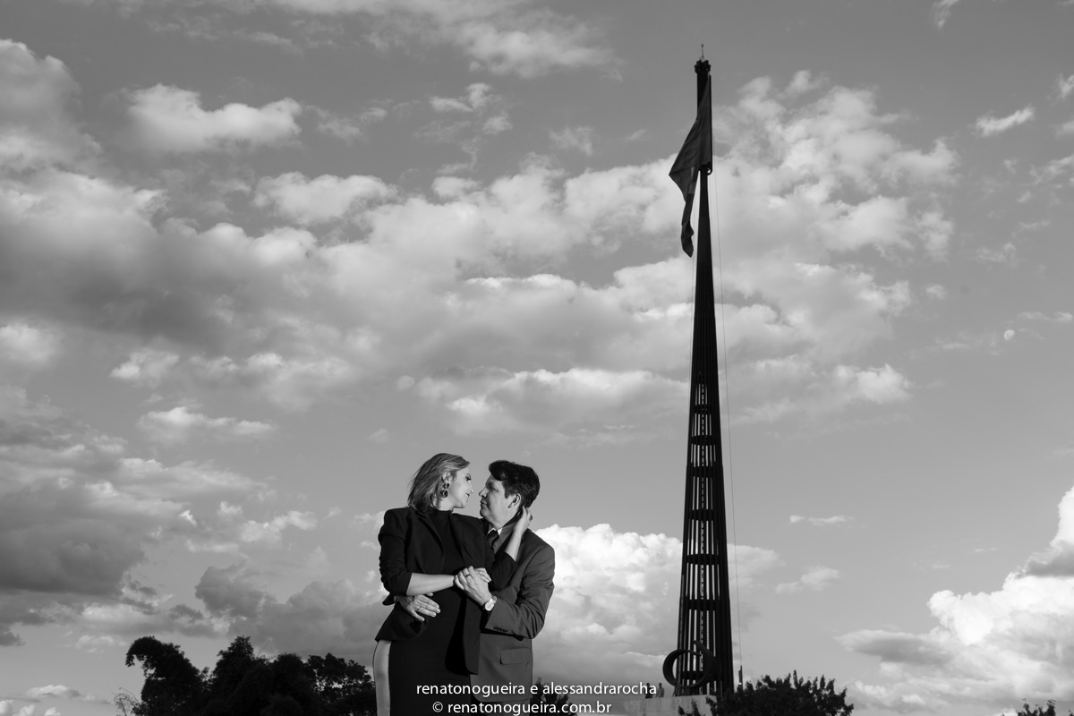 Noivos em momento de carinho em frente a bandeira nacional em Brasília.