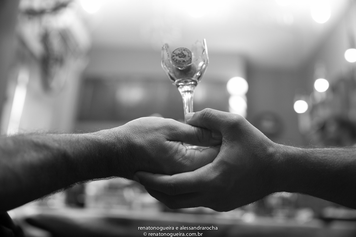 Noivos segurando a taça