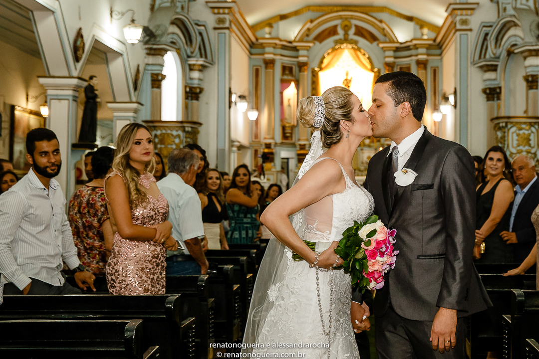 noivos beijando na saida da igreja