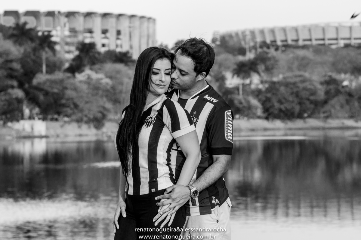 Noivos fazendo carinho com a camisa do time e os estadios de minas no fundo
