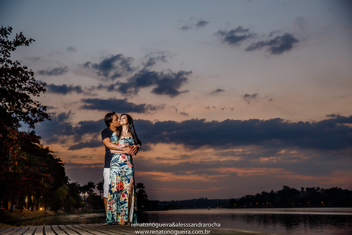 fotografia dos noivos fazendo carinho no por do sol na Pampulha
